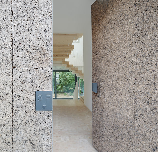 The entrance door is clad in cork panels like the facade. (photo: Gui Rebelo / rundzwei Architekten)