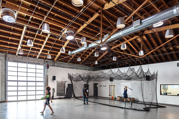 The athletics space, which features and indoor batting cage and is also bathed in natural light from the solatubes above and translucent glass roll-up door.