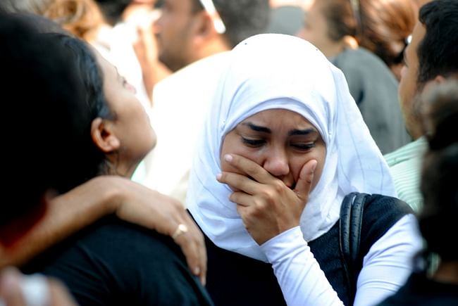 A Muslim woman comforts her Coptic Christian friend who lost a loved one in the Maspero massacre. Credit: Wikipedia