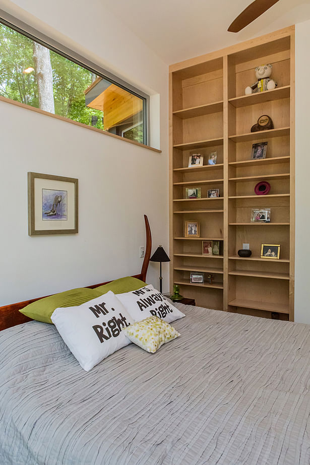  A custom bookcase recessed into the master bedroom wall is one of many space saving features.
