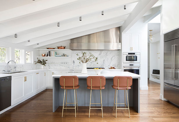 Jennifer Jones of Niche Interiors paired the cool hues of the kitchen's Caesarstone counters and stainless hood with leather upholstered Petra stools by Thomas Hayes Studio.