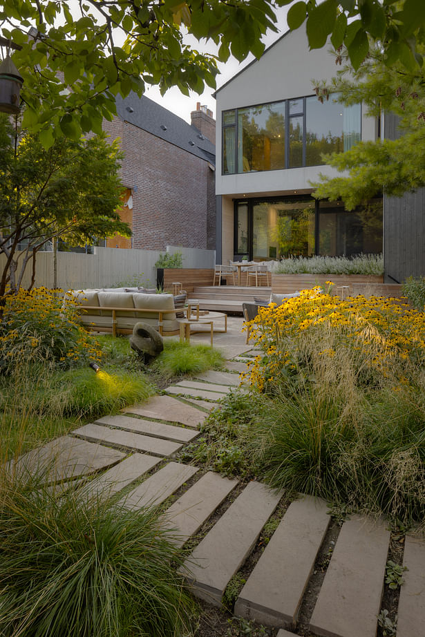 Approach to the patio through the carpet of grasses and perennials