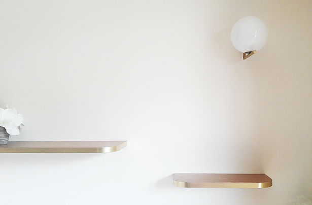 shelves with brass border and a Flos IC lamp above them
