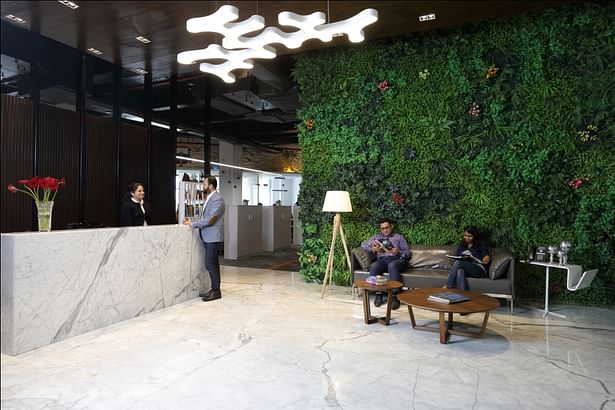 Reception Area: The plush reception welcomes warmly, with its righteous infusion of a modern interior with an al-fresco spirit rendered by the large green wall. The muted colours of grey, white along with walnuts used in the décor, set the right canvas for the green wall.