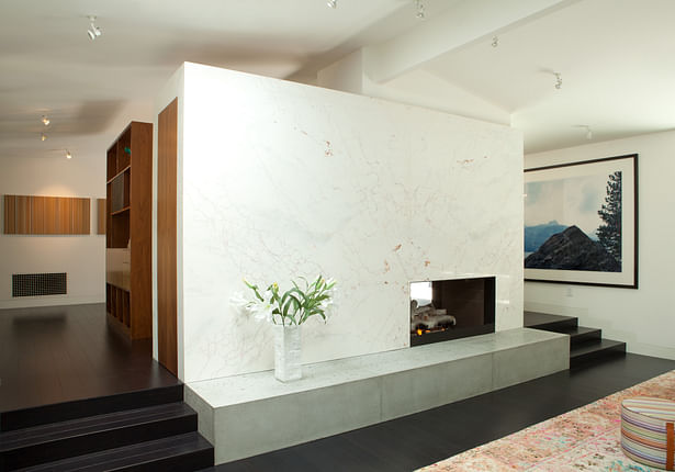 A new double sided fire-place divides the living and dining areas, and negotiates the drop in level between those two rooms. The stone is Italian dolomite, the hearth is solid poured concrete and the firebox is framed in blackened steel.