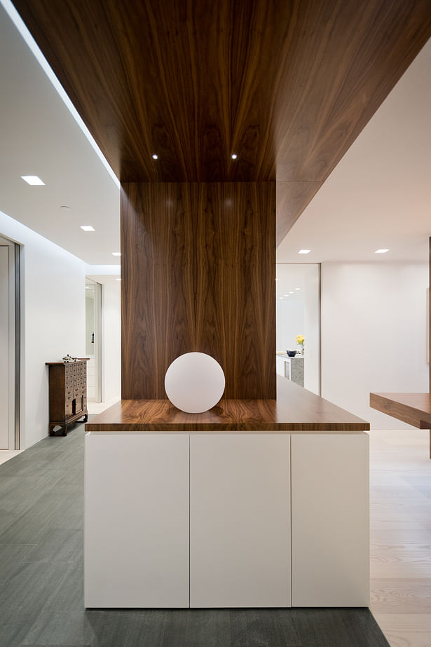 A Walnut Portal Creates a Threshold from Entry to Living Space