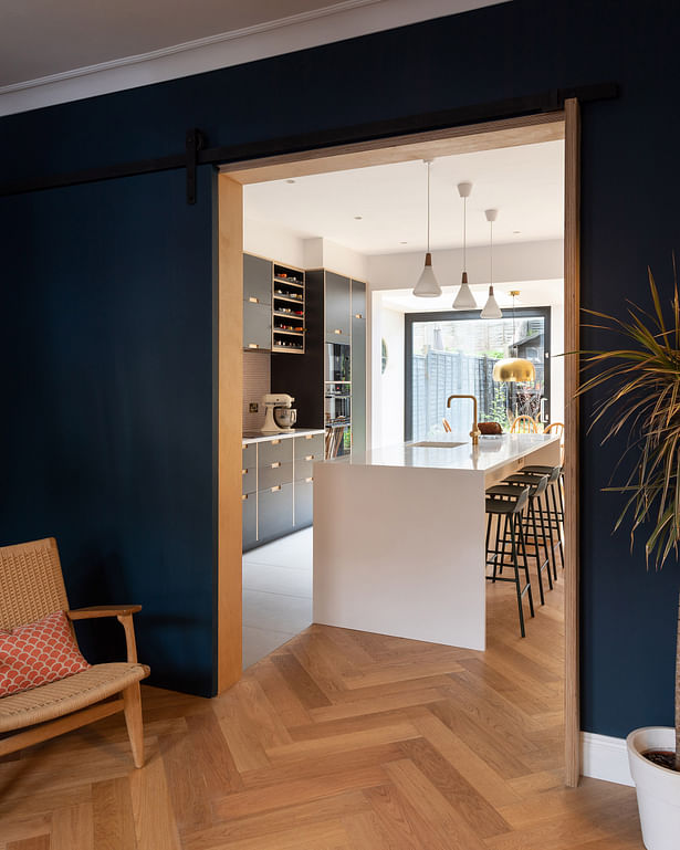 A large sliding door, lined in birch plywood, provides the option to close off the front living room from the open-plan space to the rear. Oak parquet flows throughout the ground floor. Photograph by Adam Scott