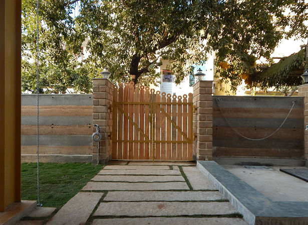 Layered rammed earth compound wall and the raw pine wood gate