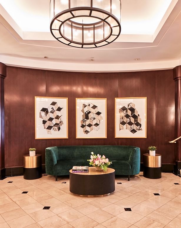 Rich, dark wood wraps the walls of the lobby and are met with warm-toned brass and deep emerald green in contemporary Art Deco style. (courtesy: The Dagny Boston)