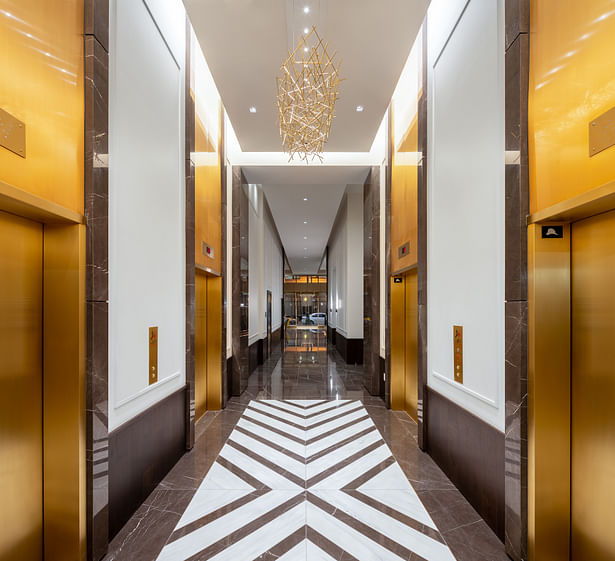 In the lift lobby, rich, dark wood wraps up the walls to wainscoting height while patterned tiles are laid in graphic repetition. (credit: Hunter Kerhart)