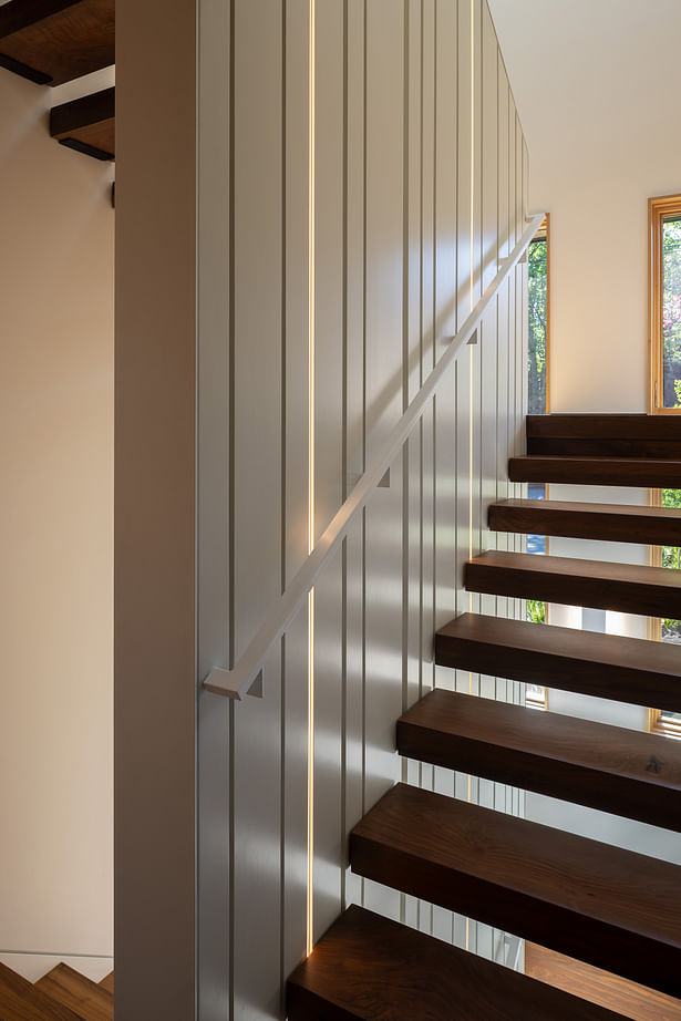 The stair connecting the three levels of the house features inlaid LED lights extending from bottom to top. Photography: Andrew Pogue Photography