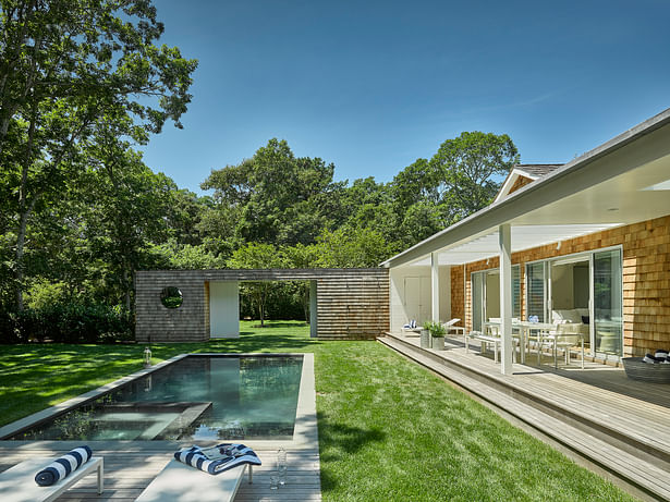Outside, a large double-thick, cedar-clad wall with a sliding barn entry gate provides privacy from the street, allowing undisturbed enjoyment of the pool and sun deck.