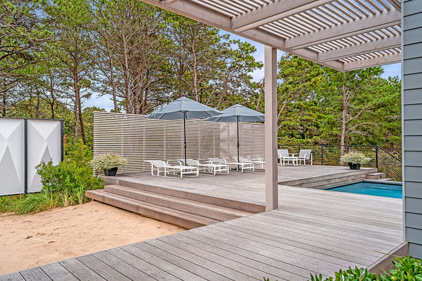 The pool deck uses a cedar slat screen wall to screen the neighbors from view. Credit: Brian Bailey