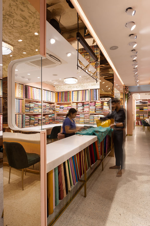 The island display counter allowing interaction of visitors with the fabrics. Photographer: Dhrupad Shukla