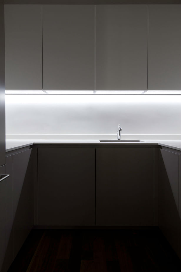 Hidden to the left is a small pantry of 6 square meters; despite its small dimension, the efficient design has made possible the inclusion of: refrigerator and freezer, microwave, oven, a secondary sink and more cabinets that enable the main kitchen to maintain its minimalist aesthetic and the clutter to be hidden away.