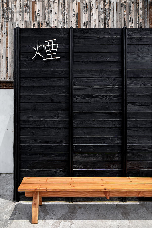 The traditional cypress bench contrasts the Shou Sugi Ban Siding to create an elegant facade.​