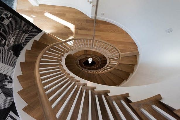 Elliptical wooden stairs topped with a skylight