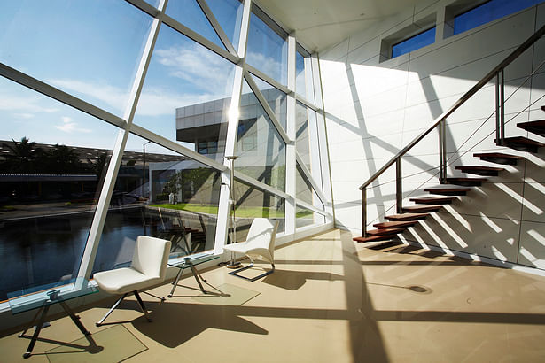 The hall interacts with the pond reflecting the front of the building with large glass windows, the lines of crystal glass Silica sand.