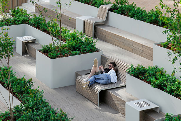 The wooden amphitheater is designed for relaxing in the shade of trees