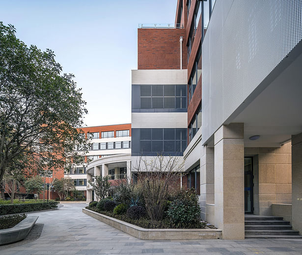 A corner of the campus, the connecting corridor and Boxue Building surrounded by flowers.