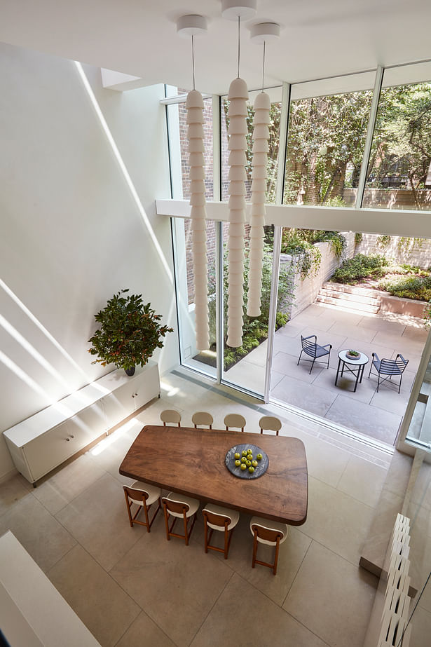The seamless connection between inside and outside is due to the continuity of surfaces and sliding doors that offer uninterrupted access to the garden from the open kitchen and dining area on that level. 
