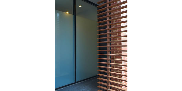 Custom steel entry louver with storefront behind. 