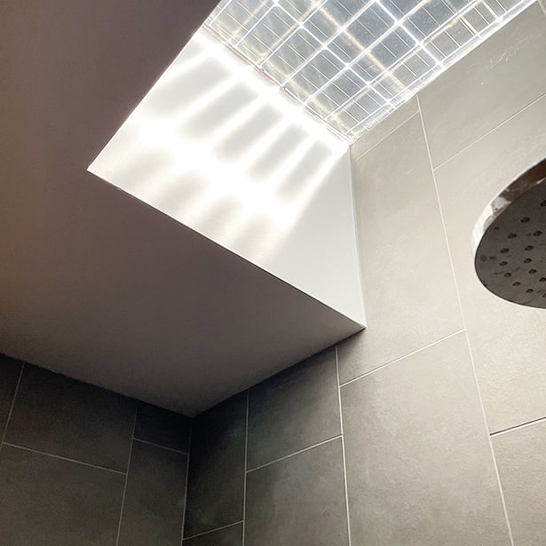 Bifacial panel over shower skylight casting shadow