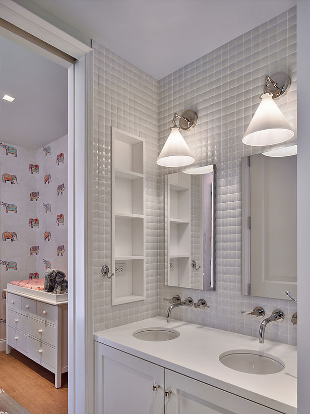The children's bathroom is a fresh white with built-in storage.