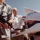 In this Thursday, Oct. 14, 1999 file photo, Ariel Sharon, center, leader of the opposition Likud party, unfurls maps of Israeli settlements in the West Bank with right-wing Knesset member Hanan Porat (AP Photo/Jacqueline Larma, File)