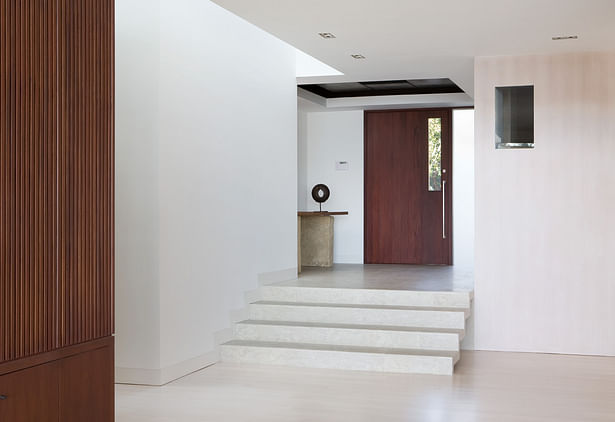 The entry vestibule is a polishes concrete floor that cascades down into the public rooms. A perimeter skylight allows sunlight to wash the wall. Recessed base boards reinforce the simplicity of the walls.