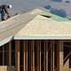 A construction worker cuts a piece of wood on the top of a home under construction at a new housing development in Petaluma, Calif. (Justin Sullivan/Getty Images via marketplace.org)