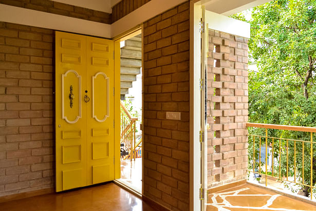 The bright yellow main door opens to the well-lit & ventilated living area