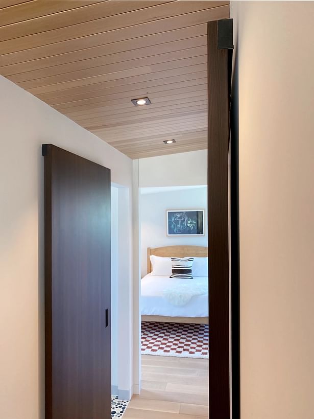 The laundry room got a Dorsis Bernero modern barn door in rich wood veneer. The sliding door panel uses the trackless Magic2 system, door pull hardware is by M&T.