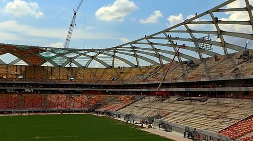 Workers are seen in the roof as construction continues at the Arena Amazonia on December 10, 2013 in Manaus, Brazil. The stadium will host matches during the 2014 FIFA World Cup Brazil. (Michael Heiman/Getty Images via Marketplace)