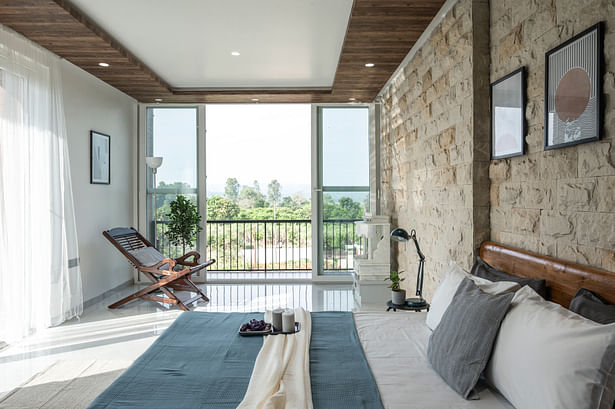 master bedroom: Locally sourced sand stone and wood have been developed and used on the walls, offering warmth to each area, giving it a contemporary yet rustic feel.