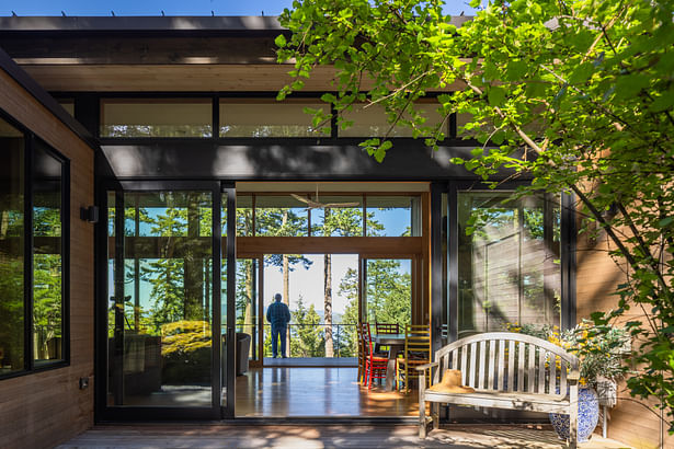 Photography: Taj Howe An outdoor protected deck in the foreground connects to the view deck perched over the trees beyond. Both exterior spaces are connected to the main indoor living.