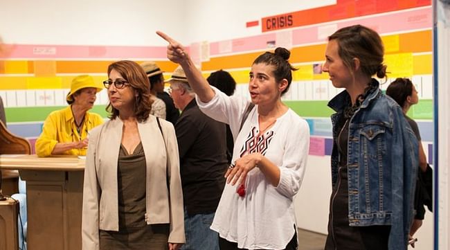 Olga Koumoundouros speaking with visitors at her exhibit. Photo by Marianne Williams. 