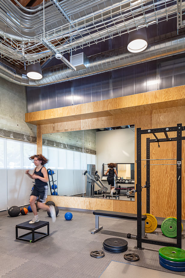 The weight training room, where the materiality of the project can be experienced in direct proximity to the industrial qualities of the building overhead.