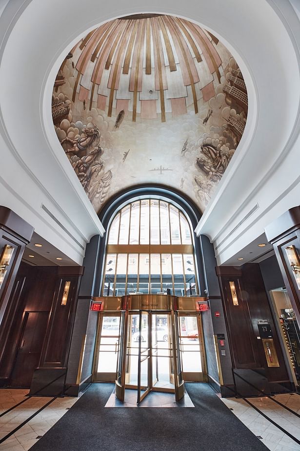 The lobby ceiling has the original gold-leaf Art Deco mural of Atlas carrying the world on his shoulders with the Boston city skyline appearing on the horizon. (courtesy: The Dagny Boston)