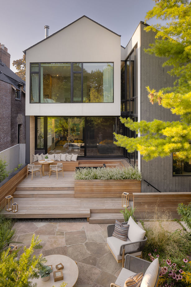 Multi-level patio with reused stone and decks cascade down from the house