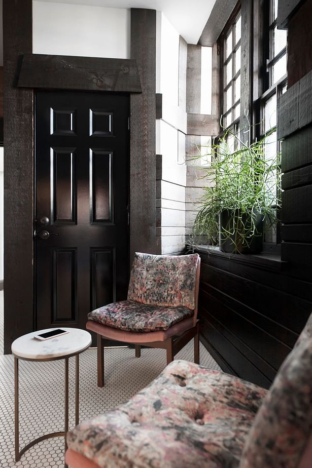 Within the lounge vintage library chairs were recovered in an opulent velvet with a heavy pattern. Marble occasional tables can be pulled up as needed. New white hex tile balances the heavy wood stain and ties into the existing flooring from the connection corridor beyond.