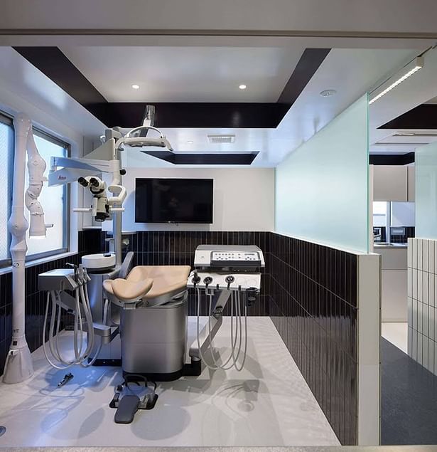 The contrast between the dark tiles and the light-colored dental unit highlights the dental chair