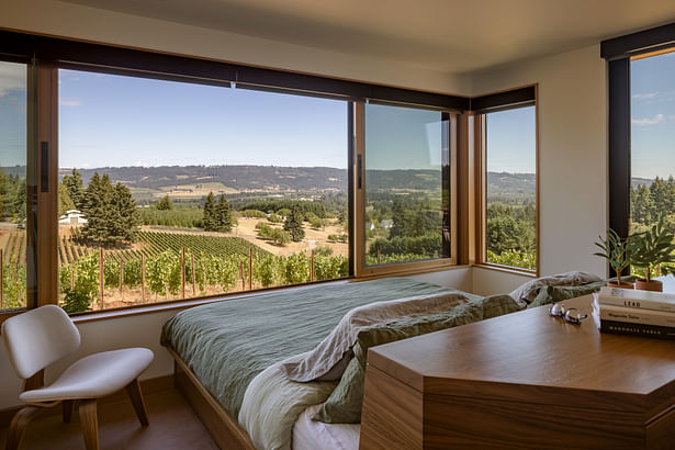 The foot of a custom bedframe sits flush against the wall and large operable window. PHOTOGRAPHER: Andrew Pogue