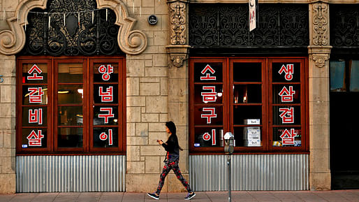 A woman walks by the Chapman Park Market, a 1928 landmark. (Rick Loomis / Los Angeles Times)