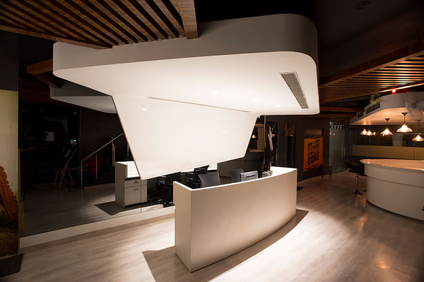 The reception dominated by a trapezoidal white ceiling welcomes the visitor inside.