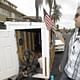 Elvis Summers, right, with a tiny house on wheels he built for Irene 'Smokie' McGhee. Photo by Damian Dovarganes / Associated Press.
