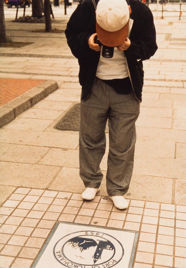 Shimbo Minami, an illustrator and cartoonist, and a member of ROJO, at work documenting the street. c. 1985. Courtesy of Tetsuo Matsuda © The ROJO Society
