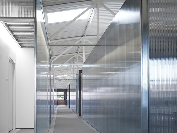 The 2nd floor workspace corridor is asymmetrically placed in order to take advantage of the existing skylight locations. The polycarbonate is transparent, reflective and private all at once.
