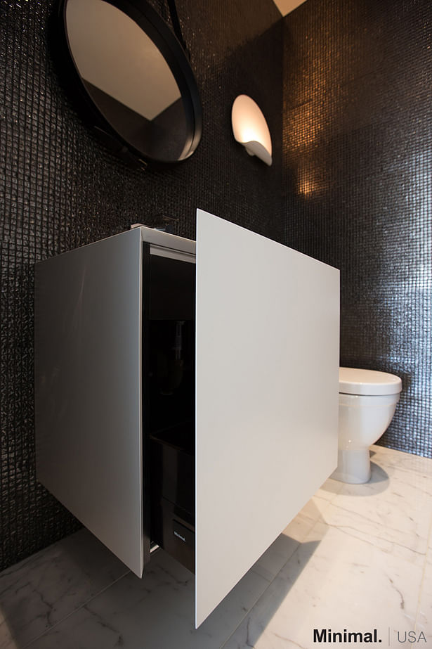 This sculpture-like cube vanity, in glossy white lacquer, not only enhances the elegance of the bathroom, but also is a sleek solution for giving more storage space, thanks to its opening bottom drawer with mitered 45° edge.