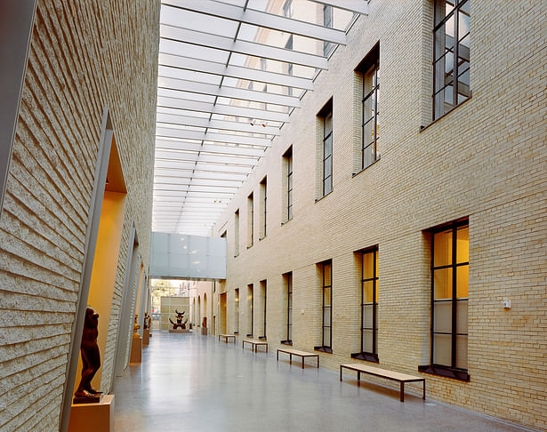 Sky-lit Galleria with corbeled cast stone wall of addition on left.